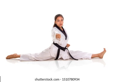 Beautiful Tae Kwon Do Girl Posing With Fist Pointed At Camera While Doing Split, Full Length Portrait, Isolated Over White Studio Background