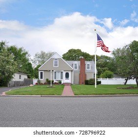 Beautiful Tan suburban bungalow style home blue sky clouds USA
