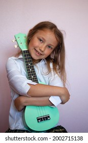 Beautiful Tanned Caucasian Girl Hugging Bright Ukulele Guitar At Music Lesson In White Shirt School Uniform Cover Photo