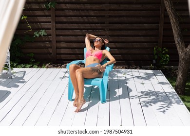 Beautiful Tanned Fit Slender Woman In Bikini In Backyard  Posing On Chair, Summer Vibes