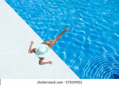 beautiful tanned sporty slim woman relaxing in swimming pool spa. 