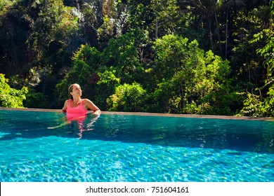 Beautiful Tanned Woman On Summer Beach Holiday Relaxing In Luxury Spa Hotel In Infinity Swimming Pool With Tropical Jungle View. Healthy Lifestyle, Family Travel Background.