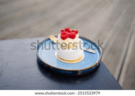 Beautiful tasty white cake with white cream and fresh raspberries at cafe. Sweet summer dieting dessert. 