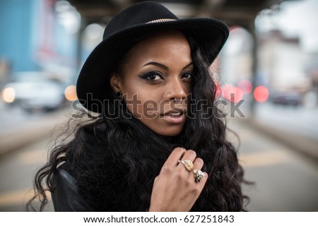 A beautiful, tattooed, black woman poses in the streets of Brooklyn, New York City. Shot during the Spring of 2017 with a shallow depth of field.