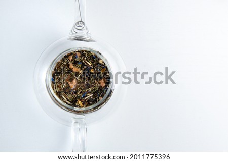 beautiful tea granules in a transparent glass teapot without water on a white background. the energy of life. photo from top to bottom. Flatlay