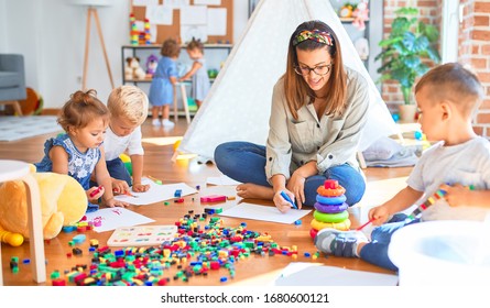 Beautiful teacher and group of toddlers playing around lots of toys at kindergarten - Shutterstock ID 1680600121