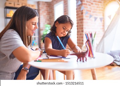 Beautiful Teacher And Toddler Girl Drawing Draw Using Colored Pencils At Kindergarten