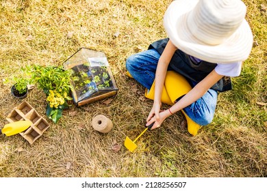 Beautiful Teen Age Girl In Black Apron And Yellow Rubber Shoes In Garden Nature And Care