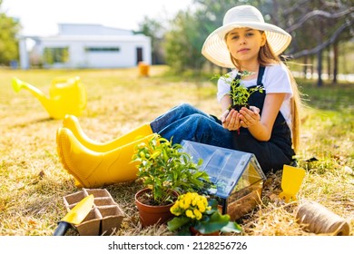 Beautiful Teen Age Girl In Black Apron And Yellow Rubber Shoes In Garden Nature And Care