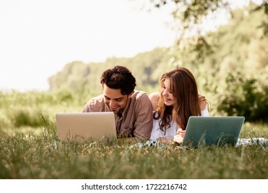 A beautiful teen couple man and women working use laptop to working at outdoor park holiday