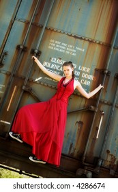 Beautiful Teen In Formalwear And Sneakers Hanging Onto A Rusty Old Boxcar.