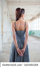 Beautiful Teen Girl In Long, Glamorous Silver Dress Going To Her Prom Or Dance. Back View