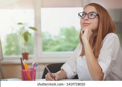 Beautiful Teenage Female Student Looking Away Dreamily, While Doing Homework, Copy Space. Happy Teen Girl Thinking, Working On School Project