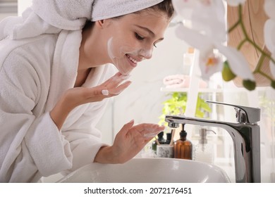 Beautiful teenage girl applying cleansing foam onto face in bathroom. Skin care cosmetic - Powered by Shutterstock