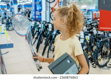 A beautiful teenage girl buys sports equipment in a sportswear store - Shutterstock ID 2360876863