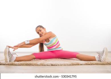 Beautiful teenage girl doing stretching exercises, girl on the carpet at home exercise. Beautiful teen girl Physical exercise doing in home environment, physical exercise for schoolchildren 
 - Powered by Shutterstock