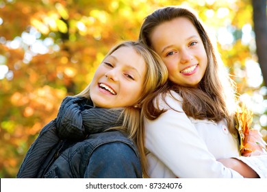 Beautiful Teenage Girls Having Fun in Autumn Park .Outdoor