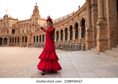 Beautiful teenage woman dancing flamenco in a square in Seville, Spain. She wears a red dress with ruffles and dances flamenco with a lot of art. Flamenco cultural heritage of humanity. - Shutterstock ID 2188958567