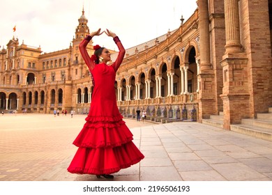 Beautiful teenage woman dancing flamenco in a square in Seville, Spain. She wears a red dress with ruffles and dances flamenco with a lot of art. Flamenco cultural heritage of humanity. - Shutterstock ID 2196506193
