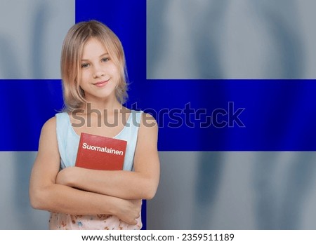Beautiful teenager girl standing with book with inscription Finnish in Finnish language on flag of Finland background