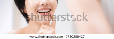 Beautiful teeth alignment checked in the mirror Imagery of orthodontics and teeth whitening