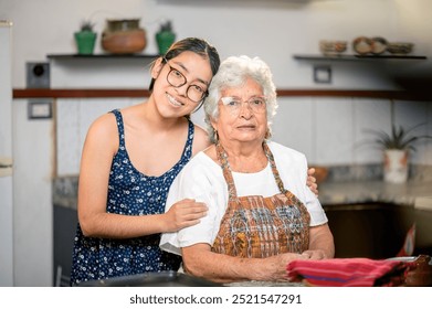 Beautiful and tender portrait of a Latina granddaughter with her grandmother in the kitchen of their home. - Powered by Shutterstock