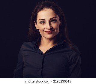 Beautiful Thinking Toothy Laughing Business Woman With Folded Arms In Blue Shirt On Black Background With Empty Copy Space For Text. Closeup Front Toned Color Portrait