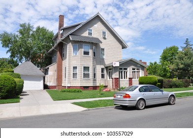 Beautiful Three Story Suburban Home Parked Car In Residential Neighborhood Sunny Cloud Filled Blue Sky Day