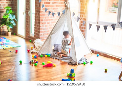 Beautiful Toddler Boy Sitting On The Floor Playing Inside  Tipi At Kindergarten