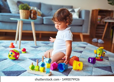 Beautiful Toddler Child Girl Playing With Toys On The Carpet