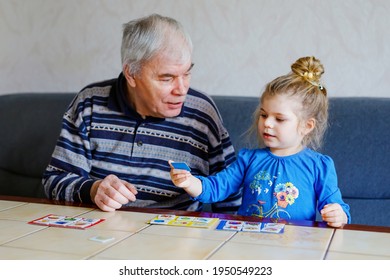 Beautiful Toddler Girl And Grandfather Playing Together Pictures Memory Table Cards Game At Home. Cute Child And Senior Man Having Fun Together. Happy Family Indoors