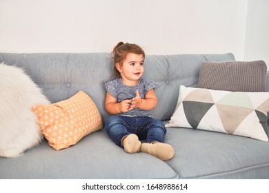 Beautiful Toddler Sitting On The Sofa Smiling At Kindergarten