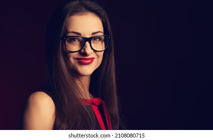 Beautiful Toothy Smiling Happy Business Woman With Red Lipstick Looking Happy In Eye Glasses In Fashion Red Dress On Dark Red Backround With Empty Copy Space. Closeup Portrait. Toned Color