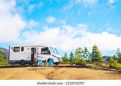 Beautiful tourism camper van campsite in the nature. Travel and rv renting vehicle vacation. Vanlife and wanderlust concept with modern motorhome parked in the nature with blue sky background