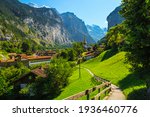 Beautiful tourist alpine village in the spectacular deep valley. Fantastic travel and touristic destination, Lauterbrunnen village with glaciers in background, Bernese Oberland, Switzerland, Europe