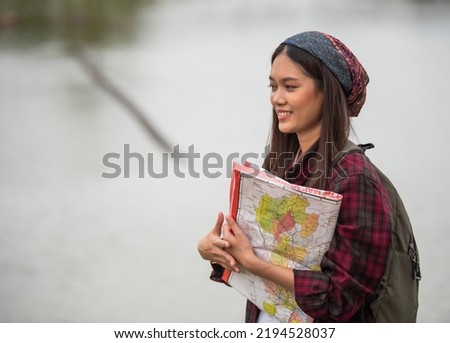 A beautiful tourist is checking the route from the map.