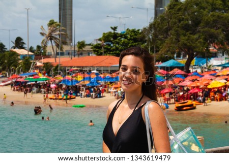 The beautiful tourist posing for photos in Redinha Beach (Natal) with  Potengi river and Newton Navarro bridge in background