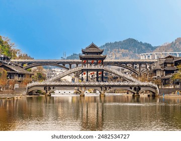 Beautiful traditional Chinese style bridges across the Tuojiang river in Fenghuang Chinese ancient village in Hunan, China under blue sky - Powered by Shutterstock