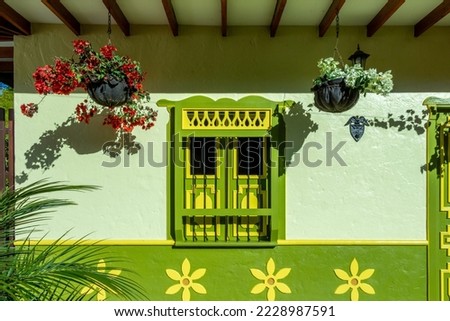 Beautiful traditional facade in the historical village of Jerico, Antioquia, Colombia. Decoration with colored designs and green plants.