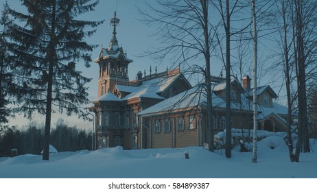 Beautiful traditional snow-covered russian cottage - terem surrounded by a forest and evergreen fir tree near it. 4K