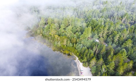 Beautiful tranquil lakeside campsite in the morning surrounded by lush green trees and fog - Powered by Shutterstock