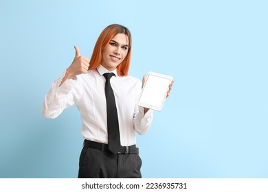 Beautiful transgender secretary with tablet computer showing thumb-up on blue background - Powered by Shutterstock