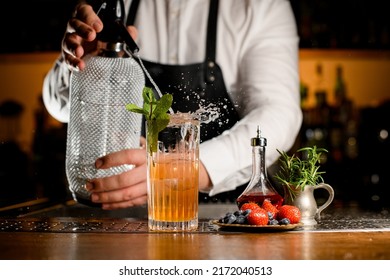 Beautiful Transparent Glass With Freshness Splashing Cocktail In Which Bartender Adds Carbonated Liquid From Siphon