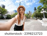 Beautiful traveler girl takes self portrait in Porto Alegre, Brazil. Young tourist woman visiting Praca da Matriz square in Porto Alegre, Rio Grande do Sul, Brazil.