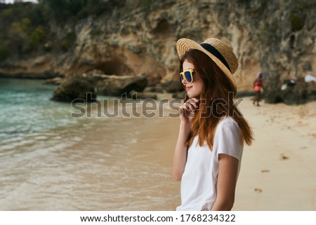 Beautiful traveler in a white T-shirt near the clear water of the ocean