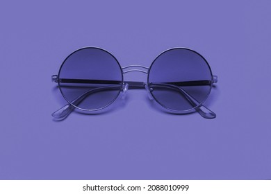 Beautiful trendy sunglasses on a pink background. New 2022 trending PANTONE 17-3938 Very Peri color

