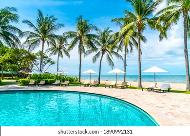 Beautiful tropical beach and sea with umbrella and chair around swimming pool in hotel resort for travel and vacation - Shutterstock ID 1890992131