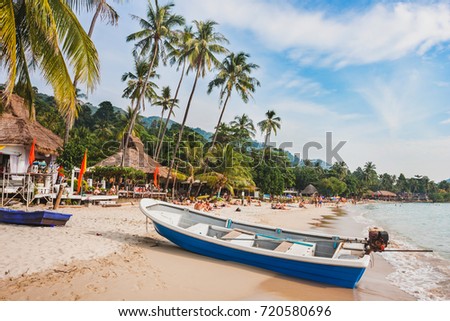 beautiful tropical beach in Thailand, wooden boat and palm trees on Koh Chang
