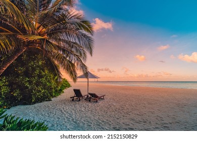 Beautiful Tropical Sunset Scenery, Two Sun Beds, Loungers, Umbrella Palm Leaves. Sand, Sea View Horizon, Colorful Sunrise Sky. Tranquil Dusk Beach Resort. Romantic Beach, Island Paradise Landscape