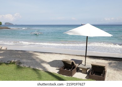 Beautiful Tropical Sunset Scenery, Two Sun Beds, Loungers, Umbrella Under Palm Tree. White Sand, Sea View With Horizon, Colorful Twilight Sky, Calmness And Relaxation. Inspirational Beach Resort Hotel